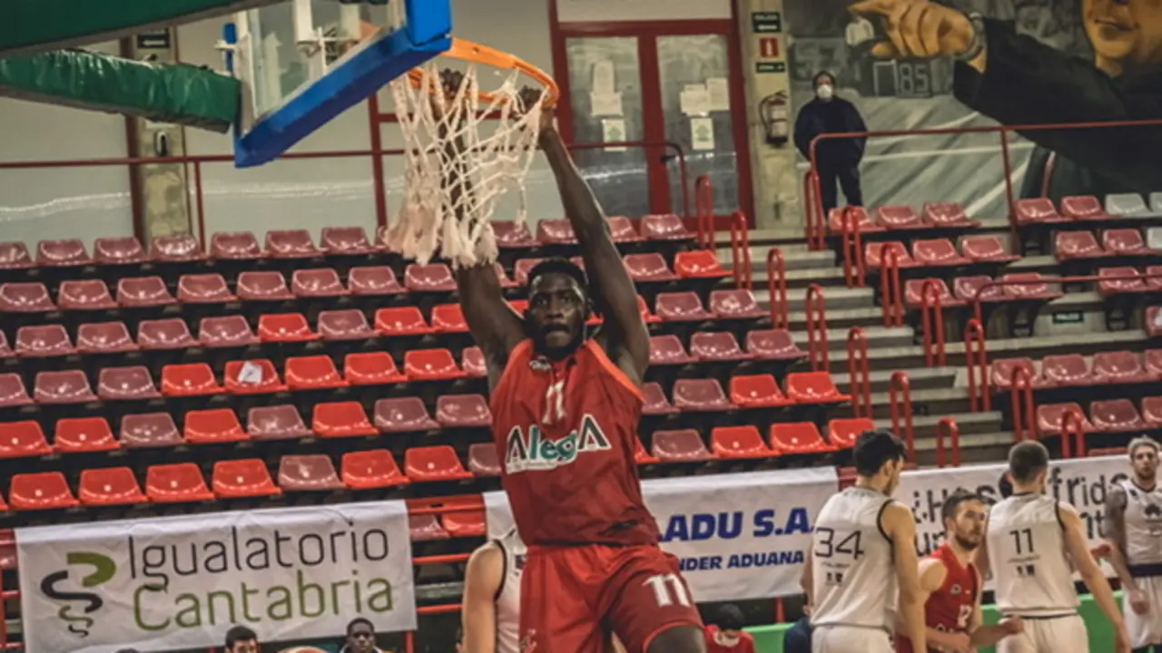 El jugador del GA Cantabria machaca la canasta mirando al c&aacute;mara.