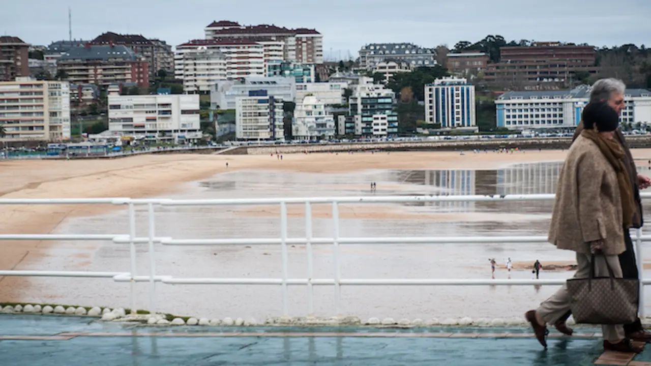Dos personas caminan junto a la playa del Sardinero en Santander. / HARDY