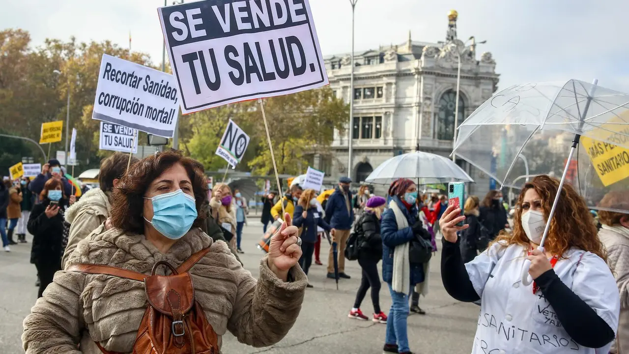 Archivo - Una mujer sostiene una pancarta donde se lee "Se vende tu salud" durante una manifestaci&oacute;n de la Marea Blanca en Madrid en noviembre de 2020. 