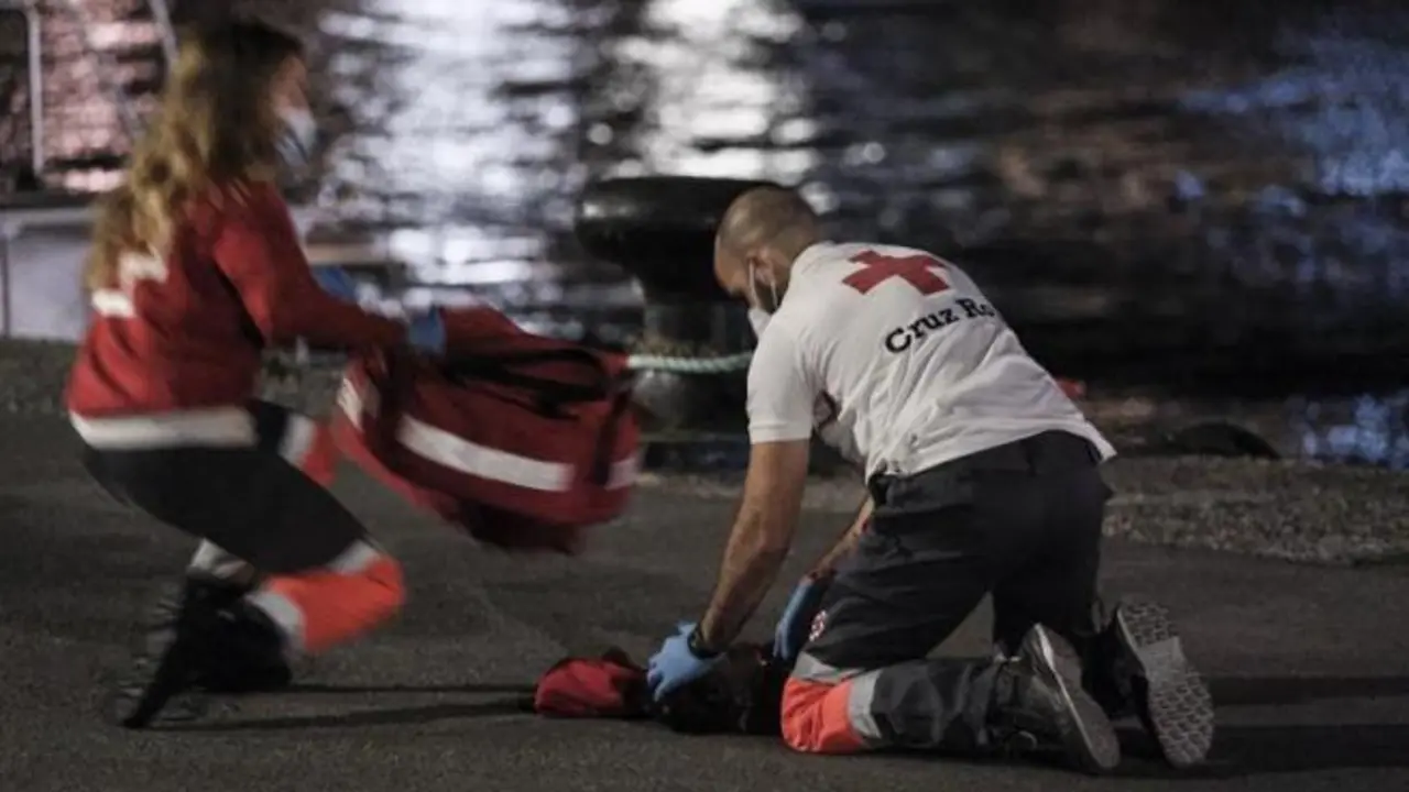Dos voluntarios de Cruz Roja y un tripulante de Salvamento Mar&iacute;timo reaniman a la ni&ntilde;a en el muelle de Arguinegu&iacute;n (Gran Canaria) este martes. EFE/ Angel Medina G.