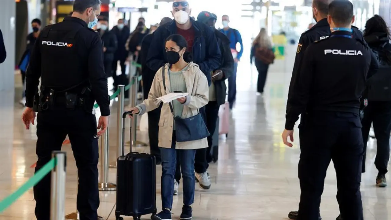 Un polic&iacute;a conversa con una viajera en el aeropuerto Adolfo Su&aacute;rez Madrid-Barajas, este viernes, D&iacute;a de San Jos&eacute;, en Madrid. Puente de San Jos&eacute; en media Espa&ntilde;a con la reducci&oacute;n de la incidencia del coronavirus estancada y todav&iacute;a por encima de los 128 casos por cada 100.000 habitantes; las autoridades sanitarias cruzan los dedos confiando en que los cierres perimetrales y las medidas de restricci&oacute;n adoptadas para los pr&oacute;ximos d&iacute;as permitan que no se invierta la tendencia a la baja. EFE/Chema Moya