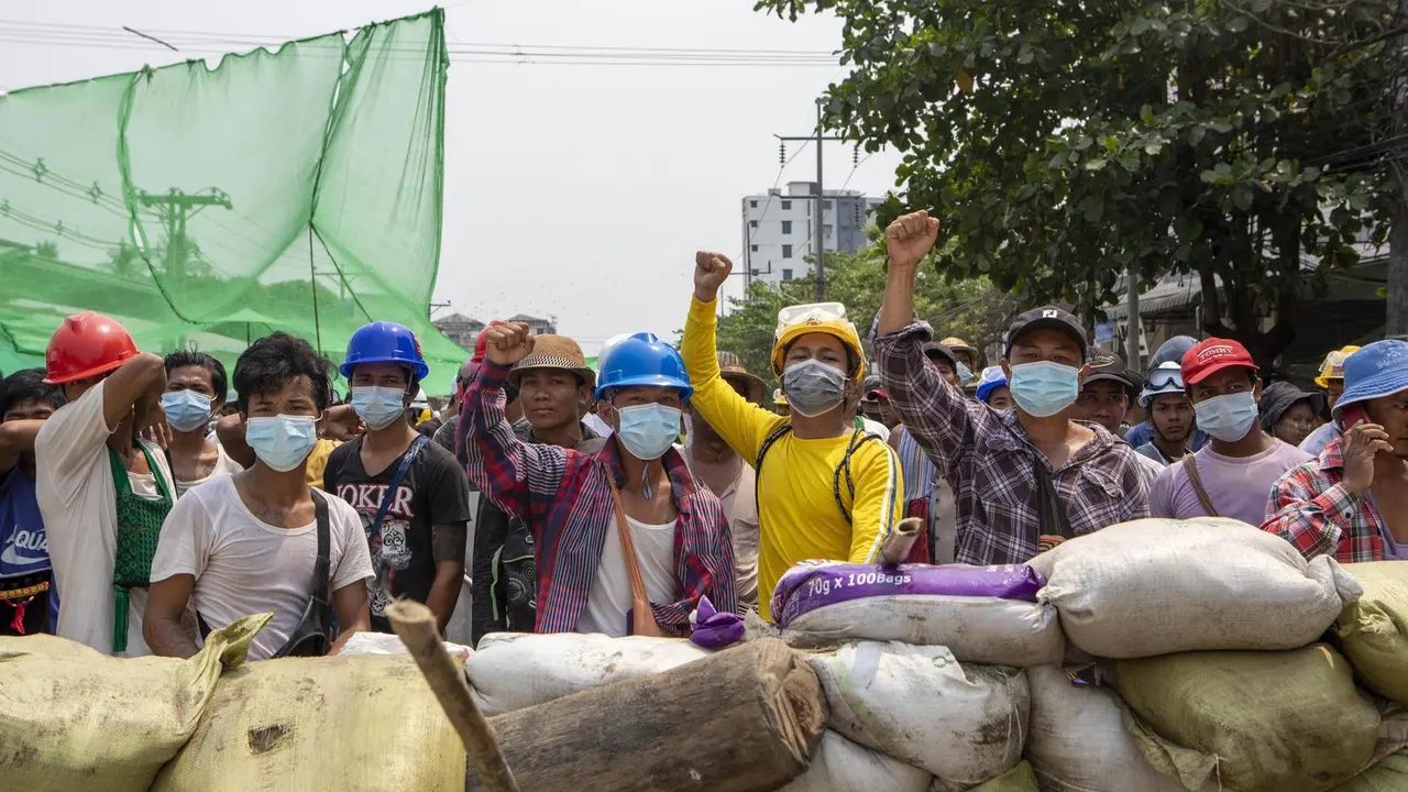 Protesters raise their fists from behind of the sand bags that block the road during the demonstration against the junta in Yangon on March 14, 2021. Thousands of people took the streets of Yangon on the 42nd day of the protest against a military coup and demanded the release of Aung San Suu Kyi. Myanmar's Military detained State Counsellor of Myanmar Sung San Suu Kyi on 1st of February, 2021 and declared a state of emergency while seizing the power in the country for a year after losing the election against the National League for Democracy.