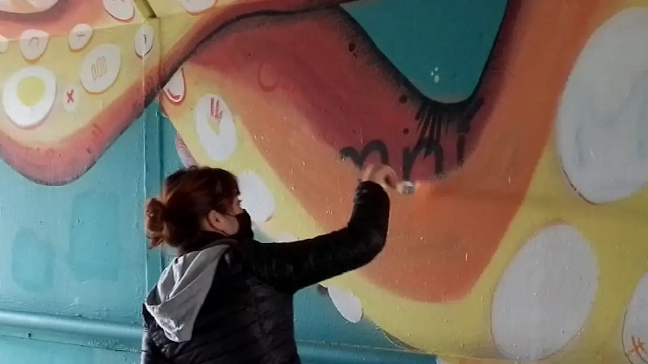 Marina Casao restaurando uno de sus murales.