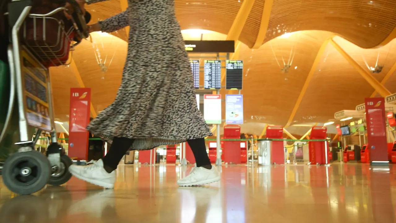 Una mujer camina con varias maletas en un carro en la terminal T4 del Aeropuerto Adolfo Su&aacute;rez Madrid-Barajas, en Madrid (Espa&ntilde;a). / Ricardo Rubio