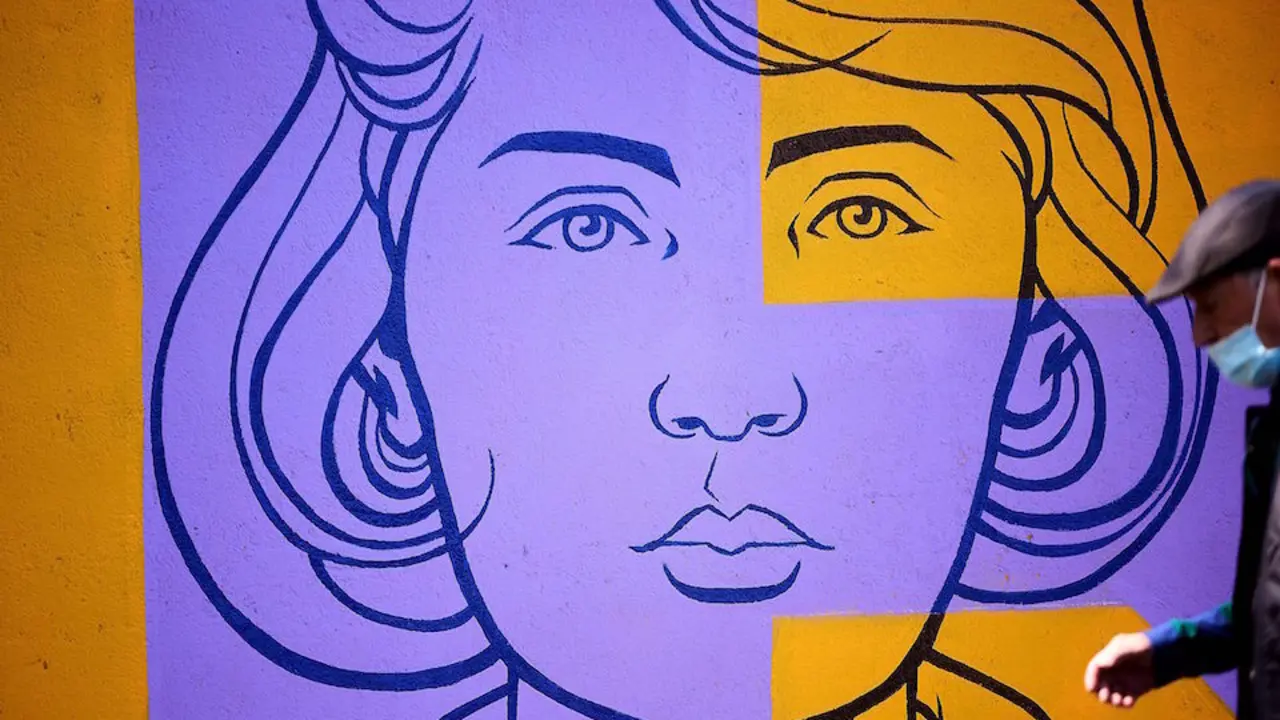 Un hombre pasa delante del mural "Sororidad" que ha confeccionado el Ayuntamiento de Talavera de la Reina en el marco del D&iacute;a Internacional de las Mujeres. / Manu Reino