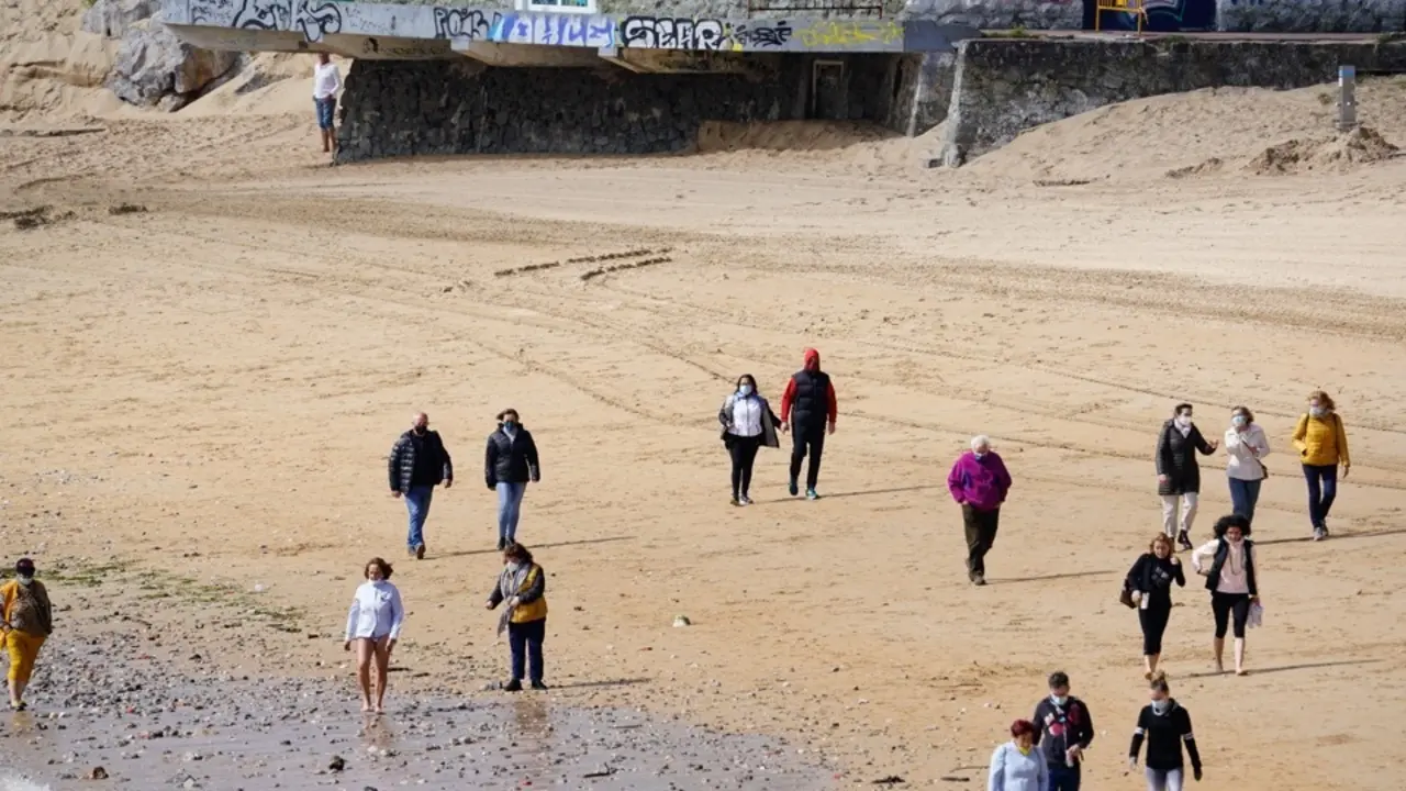 Varias personas disfrutan de la playa de Santander en el d&iacute;a de ayer, donde se mantuvo el tiempo estable. / Hardy