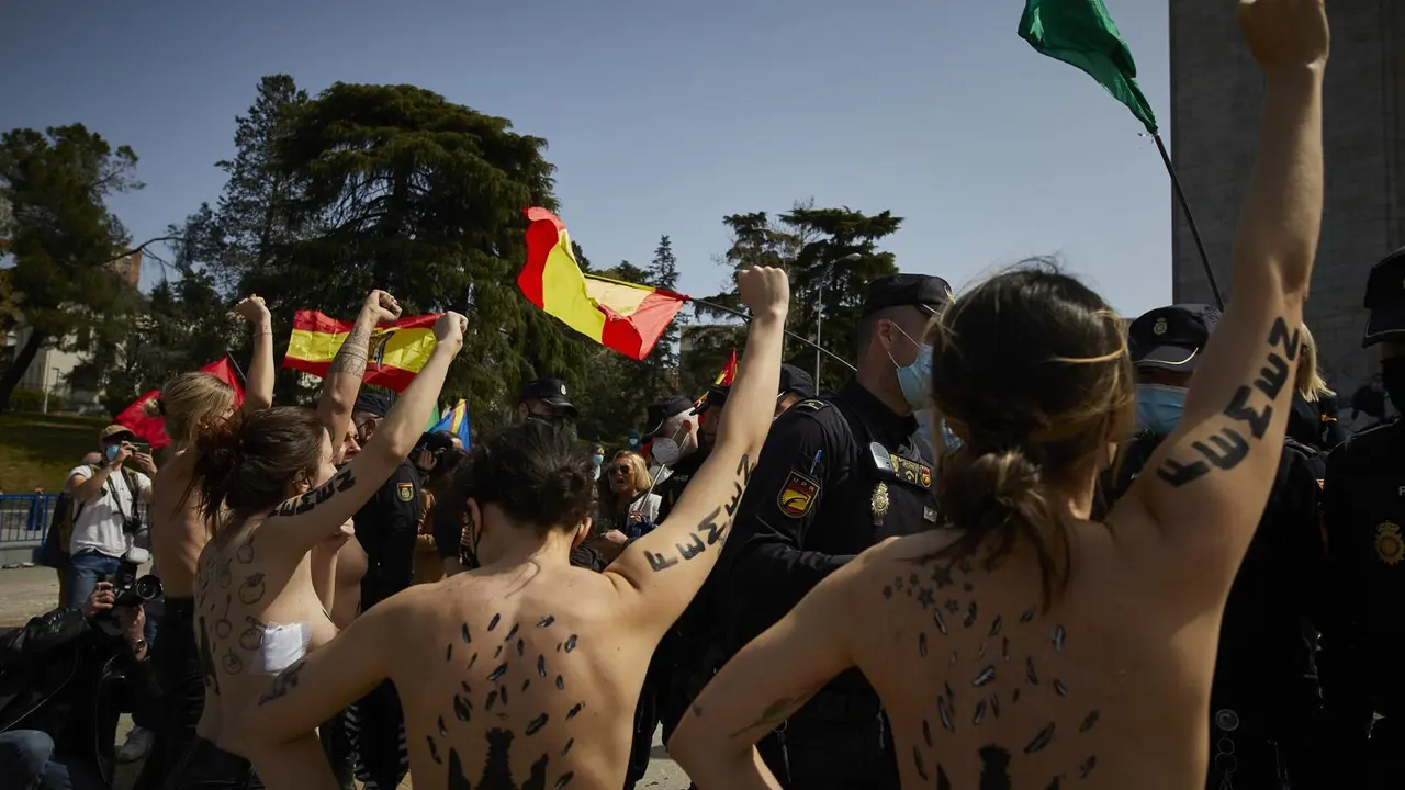 Varias activistas de Femen con &aacute;guilas franquistas dibujadas en la espalda durante un acto por el D&iacute;a de la Victoria en el LXXXII Aniversario de la &ldquo;Liberaci&oacute;n de Madrid&rdquo;, en el Arco de la Victoria, en Madrid (Espa&ntilde;a), a 28 de marzo de 2021.El colectivo a