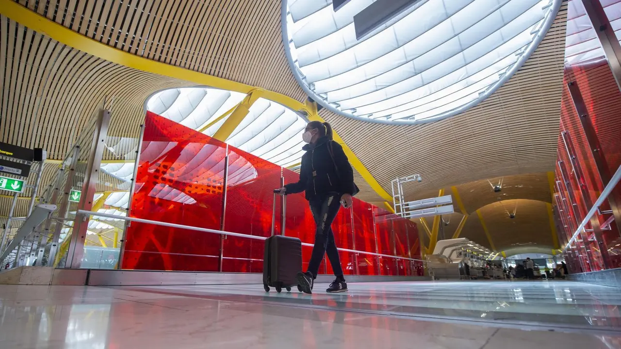 Una pasajera desplaza su maleta por las instalaciones de la T4 del Aeropuerto Adolfo Su&aacute;rez Madrid-Barajas, en Madrid (Espa&ntilde;a), a 26 de marzo de 2021. Un total de 4.818 efectivos de las Fuerzas y Cuerpos de Seguridad del Estado (FCSE) se desplegar&aacute;n esta 