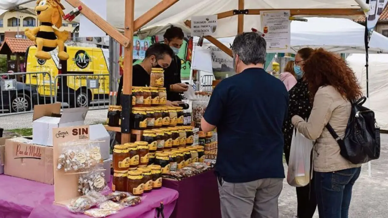Varios clientes en uno de los puestos de la Feria Agroalimentaria de Pi&eacute;lagos. / ALERTA