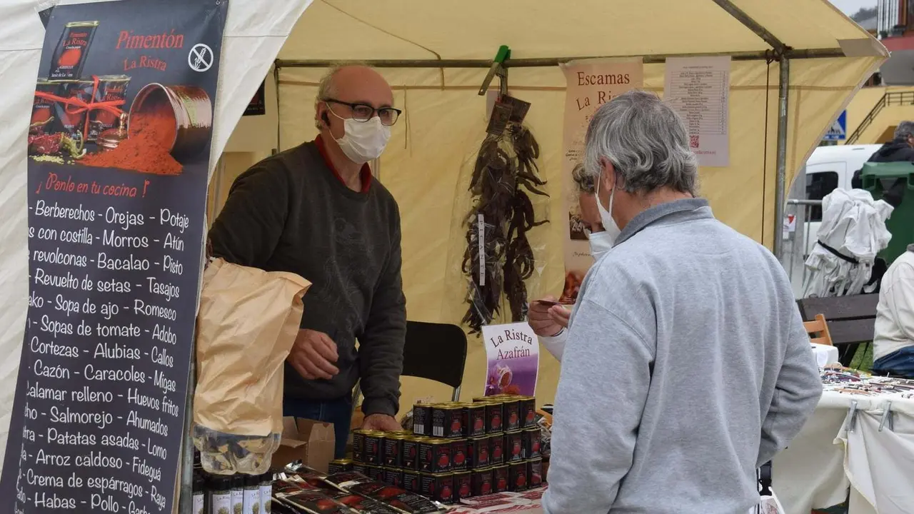 Una persona ojea los productos artesanales en un puesto del mercado de Pi&eacute;lagos en Liencres.