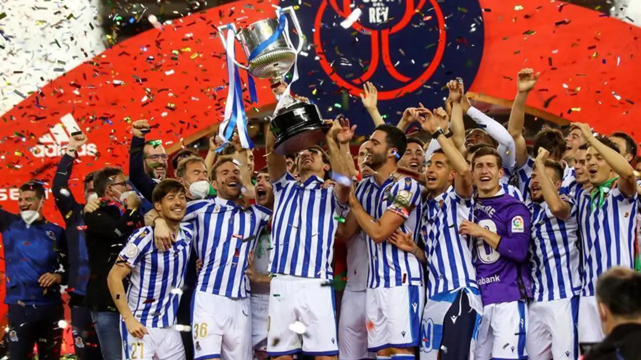 Los jugadores de la Real Sociedad tras recibir el trofeo de manos del Rey Felipe VI de Espa&ntilde;a despu&eacute;s de ganar el partido de la final de la Copa del Rey 2020 de f&uacute;tbol contra el Athletic Club en el estadio de La Cartuja en Sevilla. / RFEF