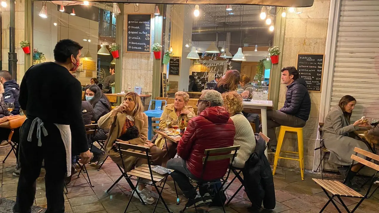 Un camarero conversa con los clientes en la terraza de un restaurante en Santander. / HARDY
