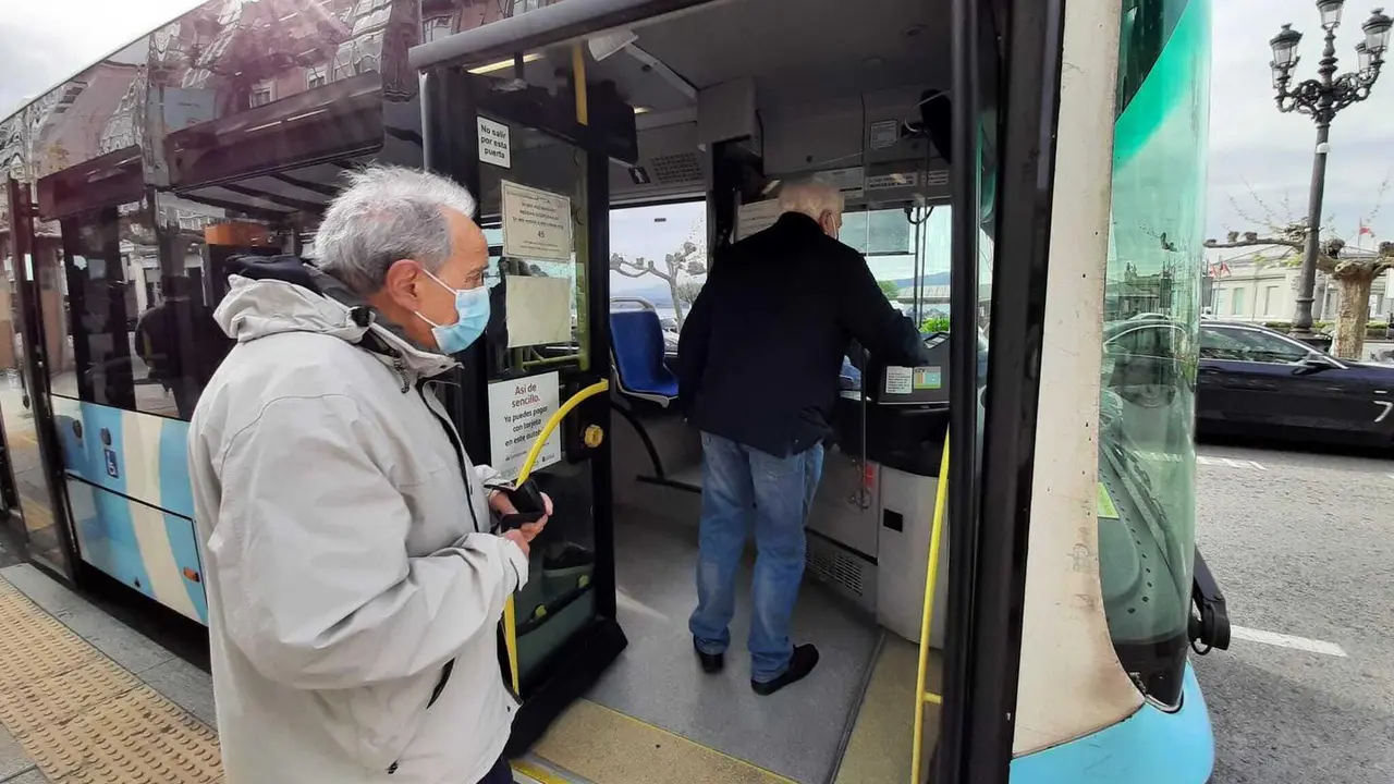 Dos personas con mascarilla suben al autob&uacute;s en Santander. / S. D&iacute;az