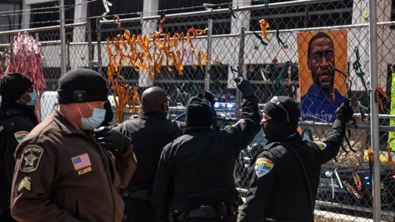 Polic&iacute;as retiran im&aacute;genes de George Floyd en las afueras del juzgado del condado de Hennepin, donde se celebra el juicio por su muerte. - -/imageSPACE via ZUMA Wire/dpa