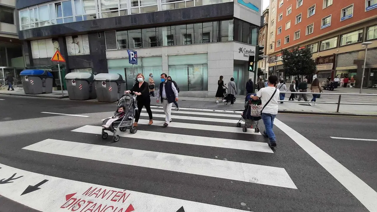 Varias personas cruzan un paso de cebra junto al Ayuntamiento de Santander. / S. D&iacute;az
