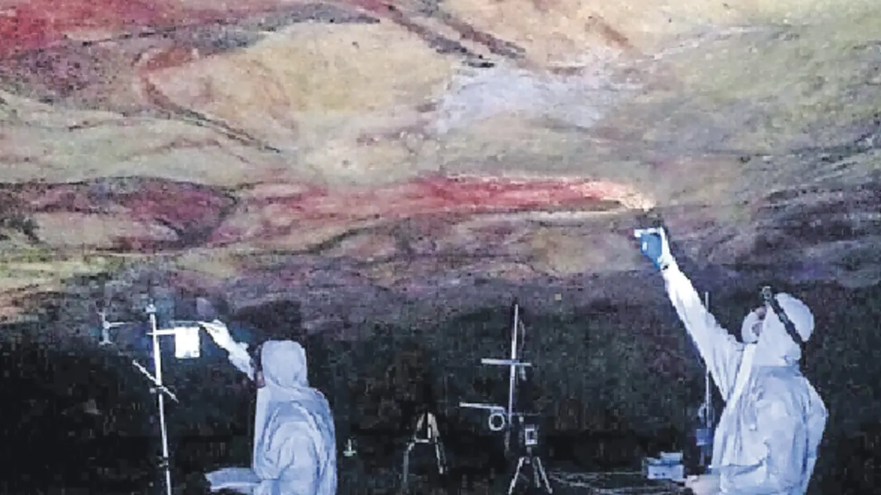 Dos operarios realizan mediciones en la cueva de Altamira. / ALERTA