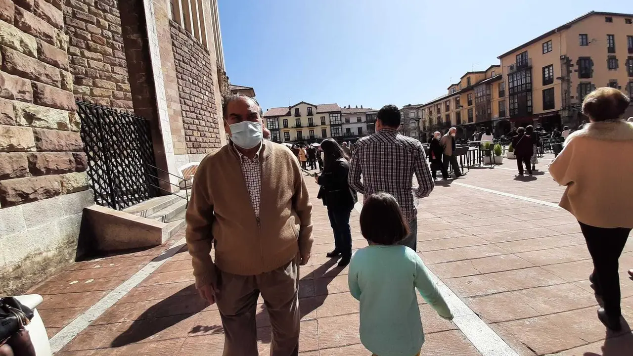 Varias personas con mascarilla transitan por la plaza Roja de Torrelavega. / S. D&iacute;az