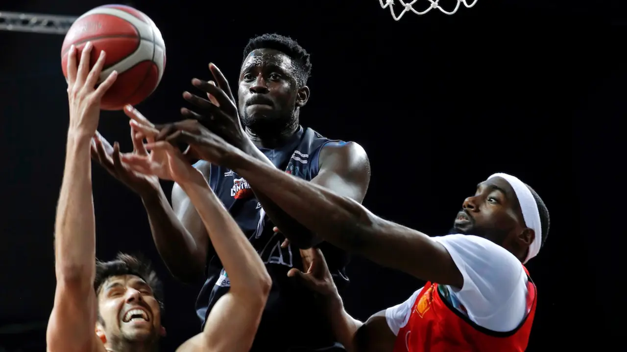 Los jugadores del Basket Navarra Adri&aacute;n Garc&iacute;a (i), y Smith (d), disputan un bal&oacute;n al jugador del Cantabria Walter Jr. (c), durante el partido de ida del Play-off disputado esta s&aacute;bado en el Navarra Arena de Pamplona.- EFE/Villar L&oacute;pez