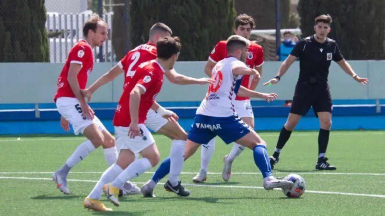 El jugador del Ebro rodeado por los jugadores del Racing.