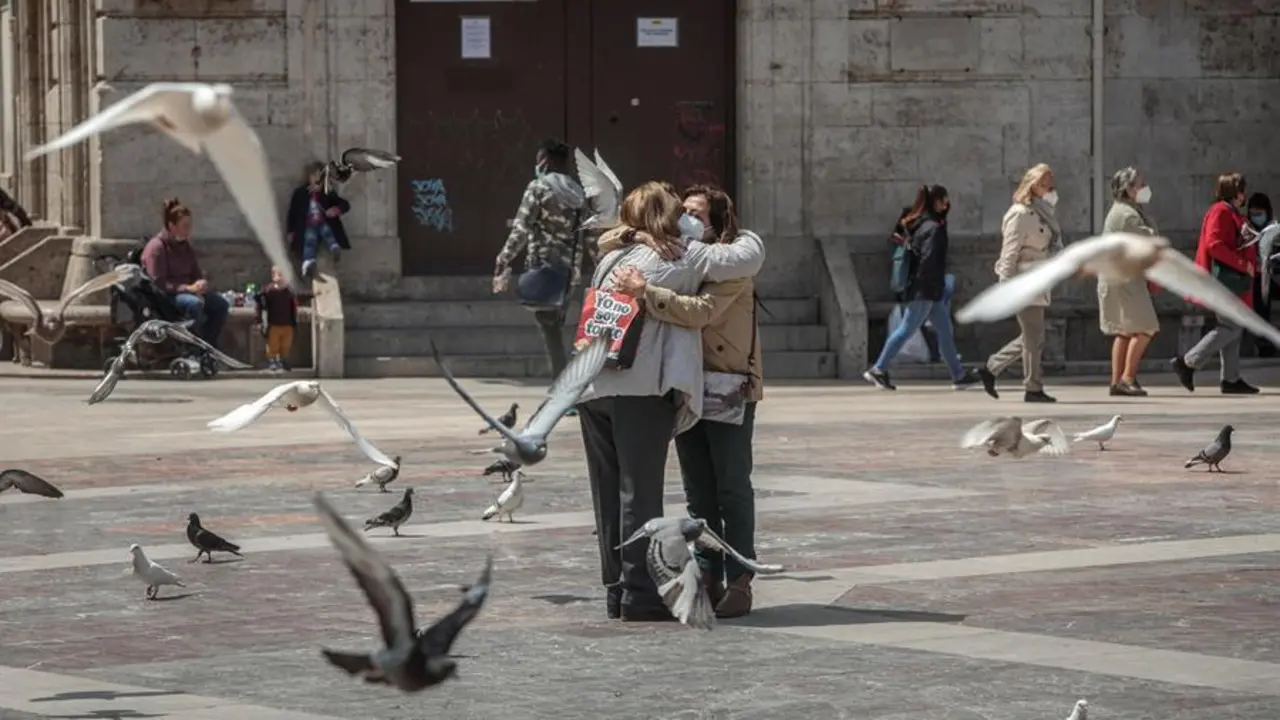 Dos personas se abrazan en una c&eacute;ntrica plaza de Val&egrave;ncia, un gesto d&iacute;f&iacute;cil de ver durante la pandemia, pero que se va recuperando a medida que avanza el proceso de vacunaci&oacute;n cuando la cifra de personas que han recibido ya las dos dosis de la vacuna contra el coronavirus en la Comunitat Valenciana, y por tanto est&aacute;n inmunizadas, se ha situado este martes en las 394.281, con lo que por primera vez supera a la de contagiadas desde el inicio de la pandemia, que son 389.706. EFE/Biel Ali&ntilde;o
