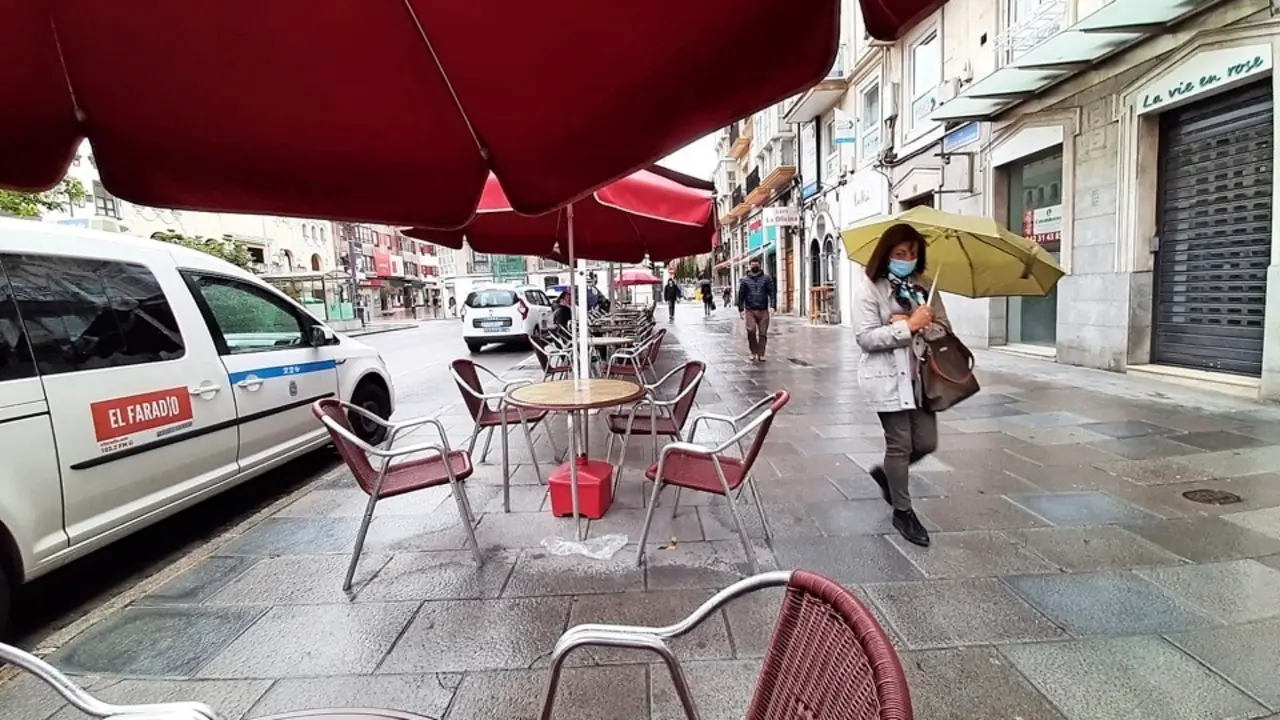 Una persona con mascarilla observa como el fot&oacute;grafo de este medio toma la instant&aacute;nea en el centro de Santander. / S. 
D&iacute;az