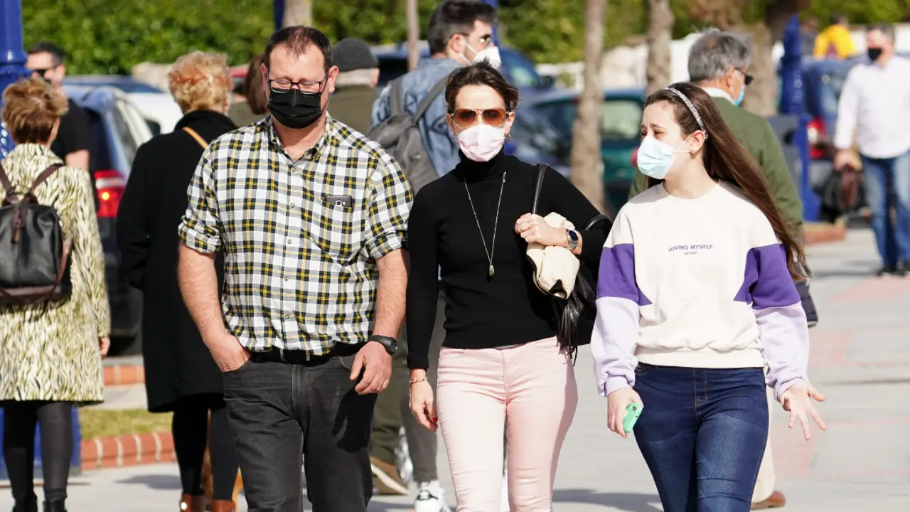 Varias personas transitan con su mascarilla puesta por las inmediaciones de la playa del Sardinero en Santander. / HARDY
