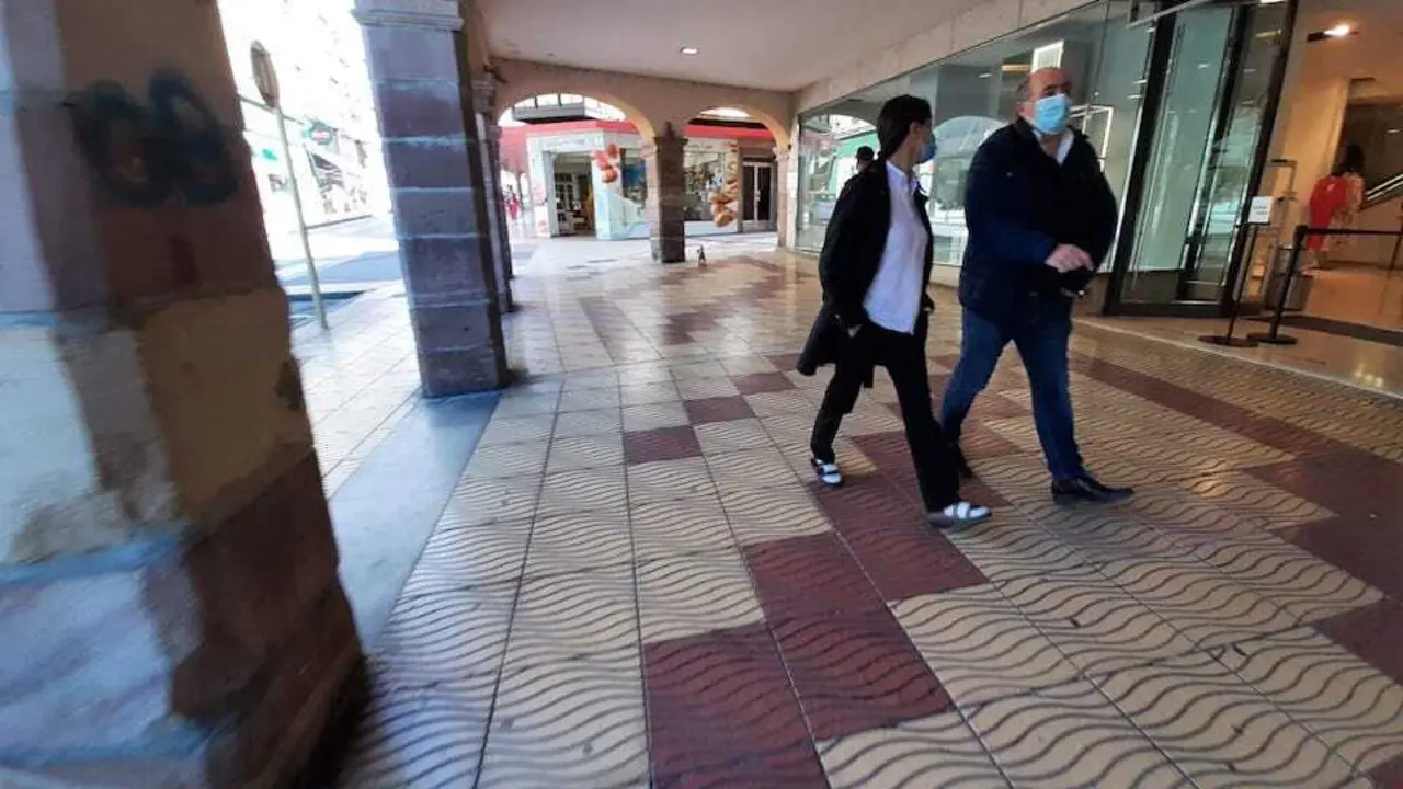 Varios torrelaveguenses con mascarilla por los soportales comerciales del centro de la ciudad.