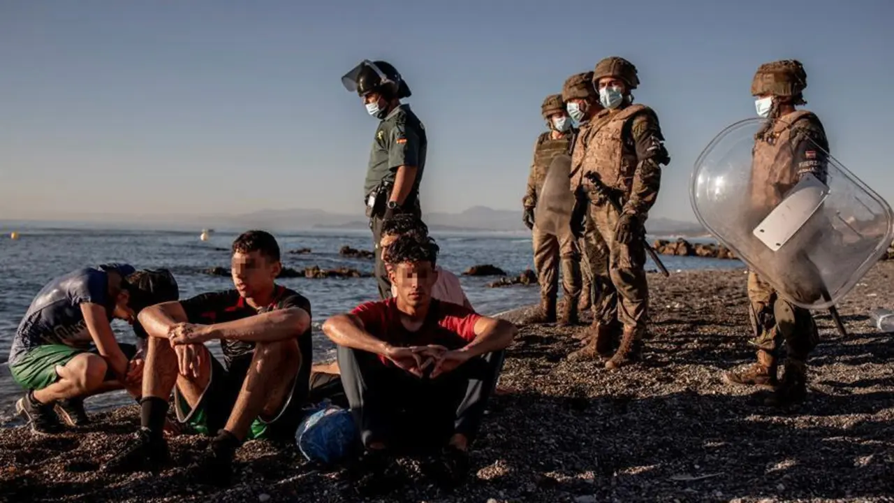 Miembros del ej&eacute;rcito observan a un grupo de inmigrantes menores a su llegada a la playa de El Tarajal en Ceuta este mi&eacute;rcoles. La frontera de Ceuta entre Marruecos y Espa&ntilde;a ha amanecido con solo unas decenas de inmigrantes que intentan llegar a nado, una situaci&oacute;n que difiere de la registrada hace dos d&iacute;as, cuando llegaron 8.000 personas, la mitad de las cuales han sido devueltas, seg&uacute;n el Gobierno espa&ntilde;ol. EFE/Brais Lorenzo