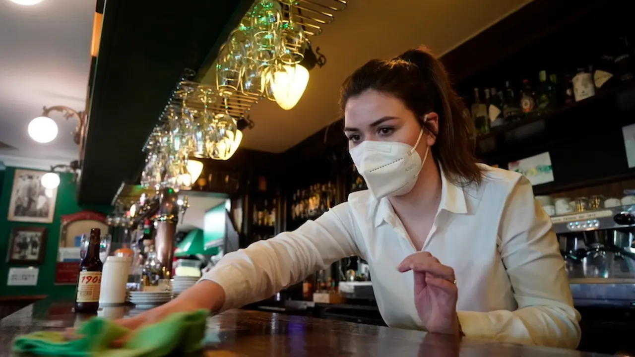 Una trabajadora de la hosteler&iacute;a repasa la barra del local tras el primer d&iacute;a del incremento del cierre. / HARDY