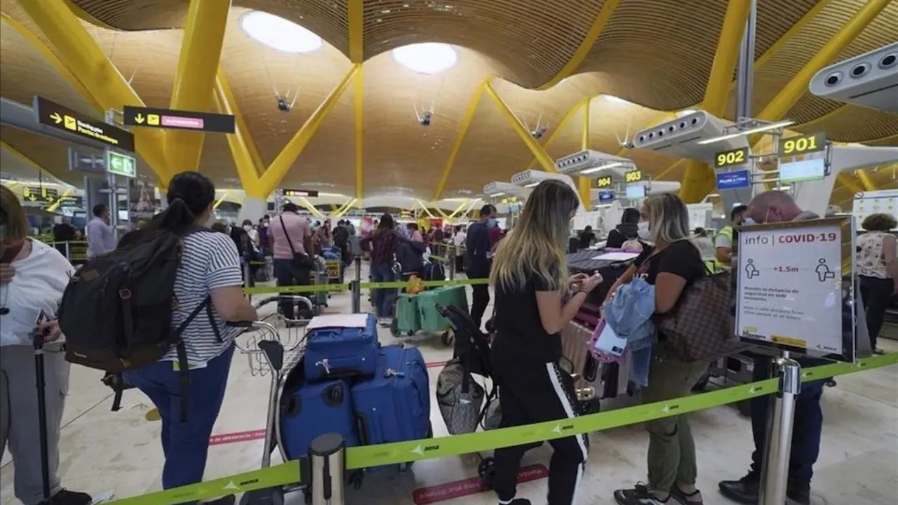 Varias personas esperan para embarcar en el aeropuerto de Barajas. / ALERTA