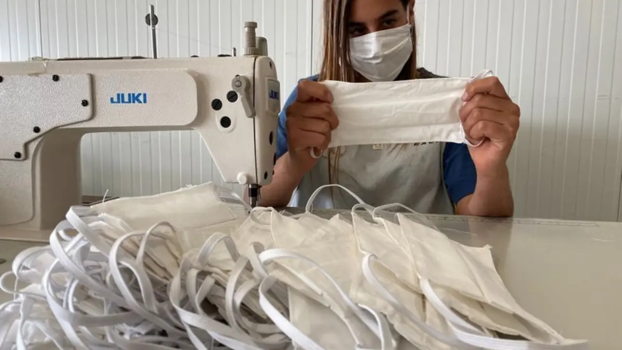 Una empleada fabrica mascarillas de tela reutilizables.