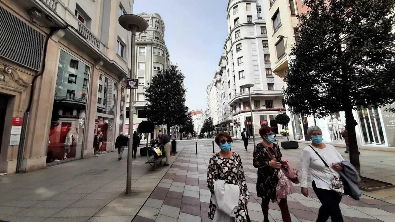 Varias personas con mascarilla caminan por una calle del centro de Santander. / S. D&iacute;az