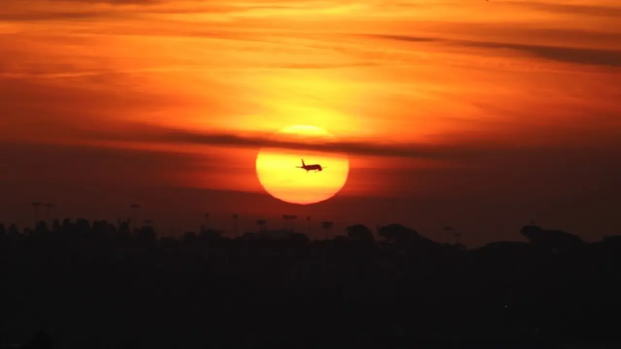 Un avi&oacute;n pasa por delante del sol. E.P.