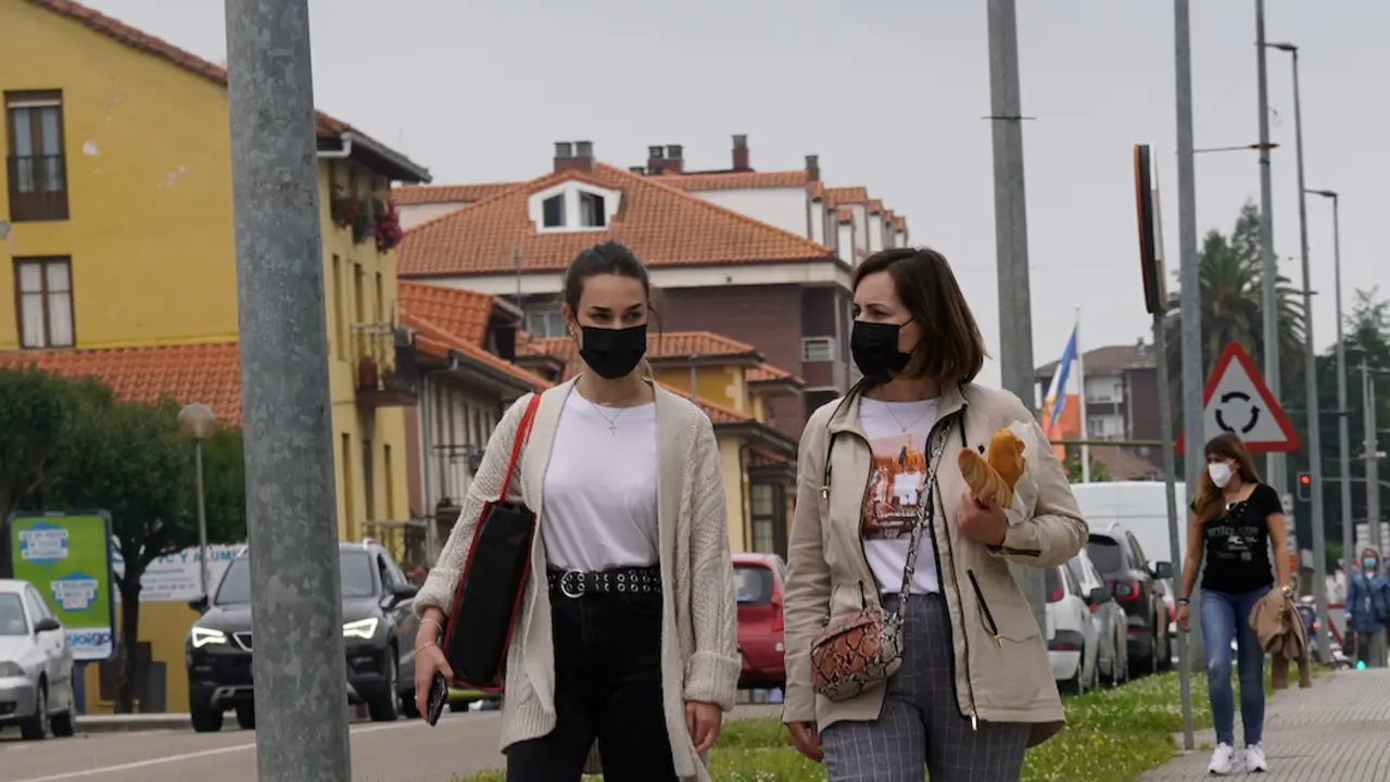 Dos personas transitan con su mascarilla por la localidad de Astillero. / Hardy