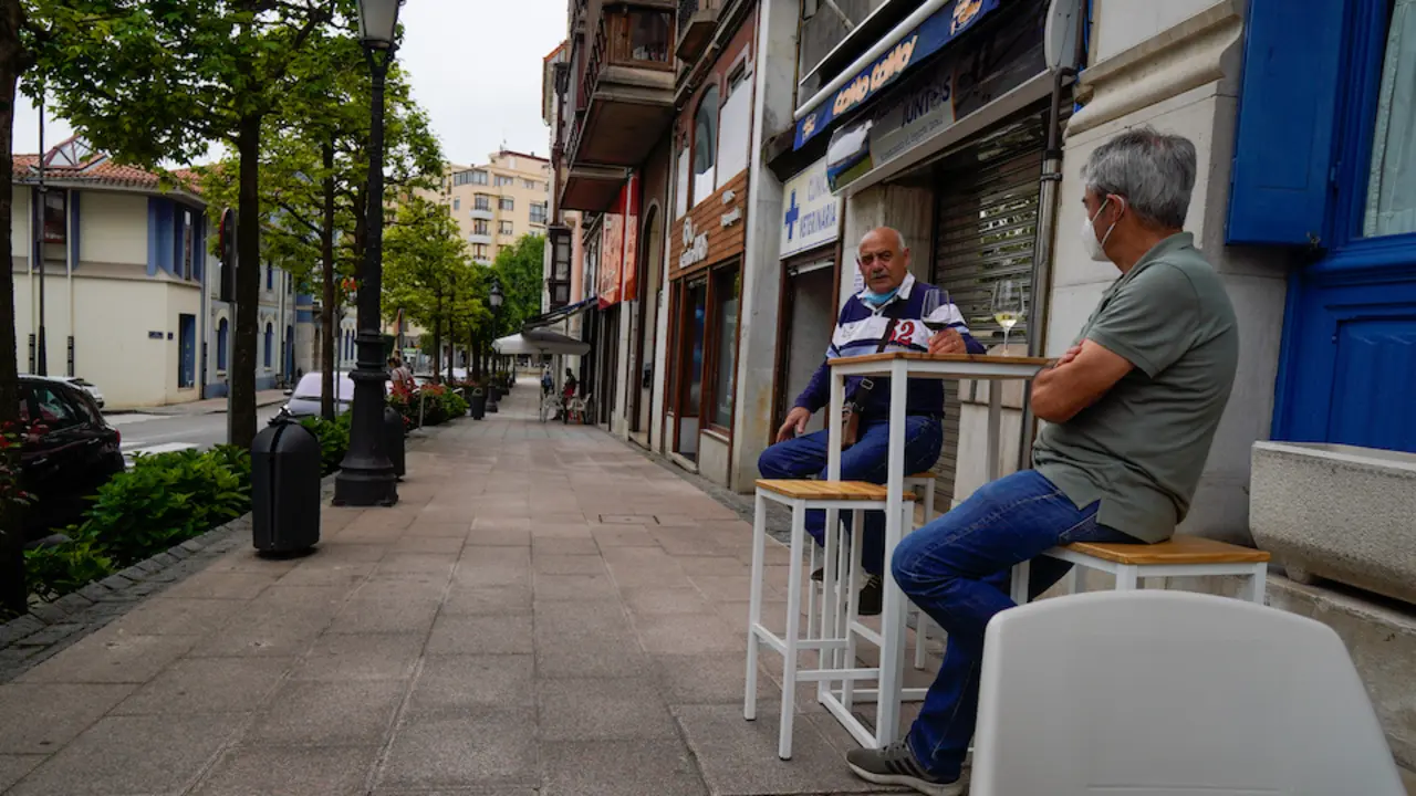 Dos personas con mascarilla en una terraza de un local de hosteler&iacute;a de Astillero. / Hardy
