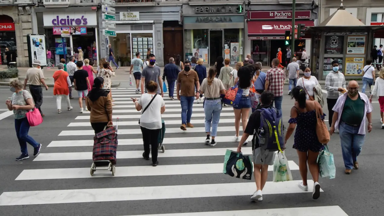 Varias personas con mascarilla cruzan una calle en el centro de Santander. / Hardy