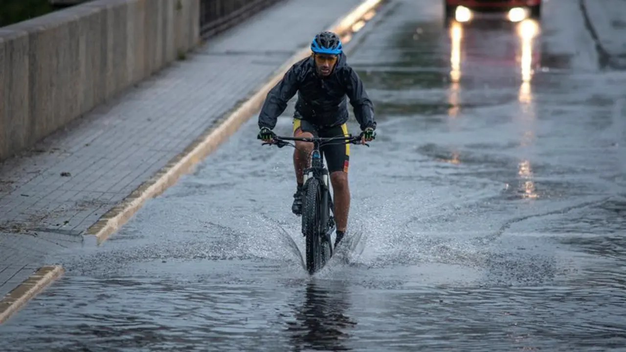 Un ciclista cruza el Puente Nuevo de Ourense bajo una intensa lluvia, este mi&eacute;rcoles. La Direcci&oacute;n Xeral de Emerxencias e Interior de la Vicepresidencia de la Xunta de Galicia ha activado una alerta naranja por tormentas y fuertes precipitaciones en las provincias de Lugo y Ourense. EFE/ Brais Lorenzo