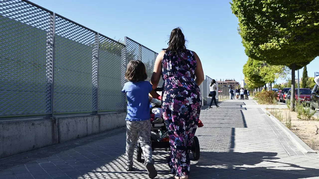 Archivo - Una madre y su hijo empujan el carrito de un beb&eacute; en un parque de Madrid.