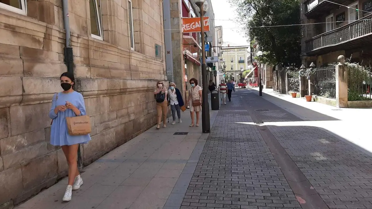 Varias personas con mascarilla circulan por el centro de Torrelavega. / S. D&iacute;az