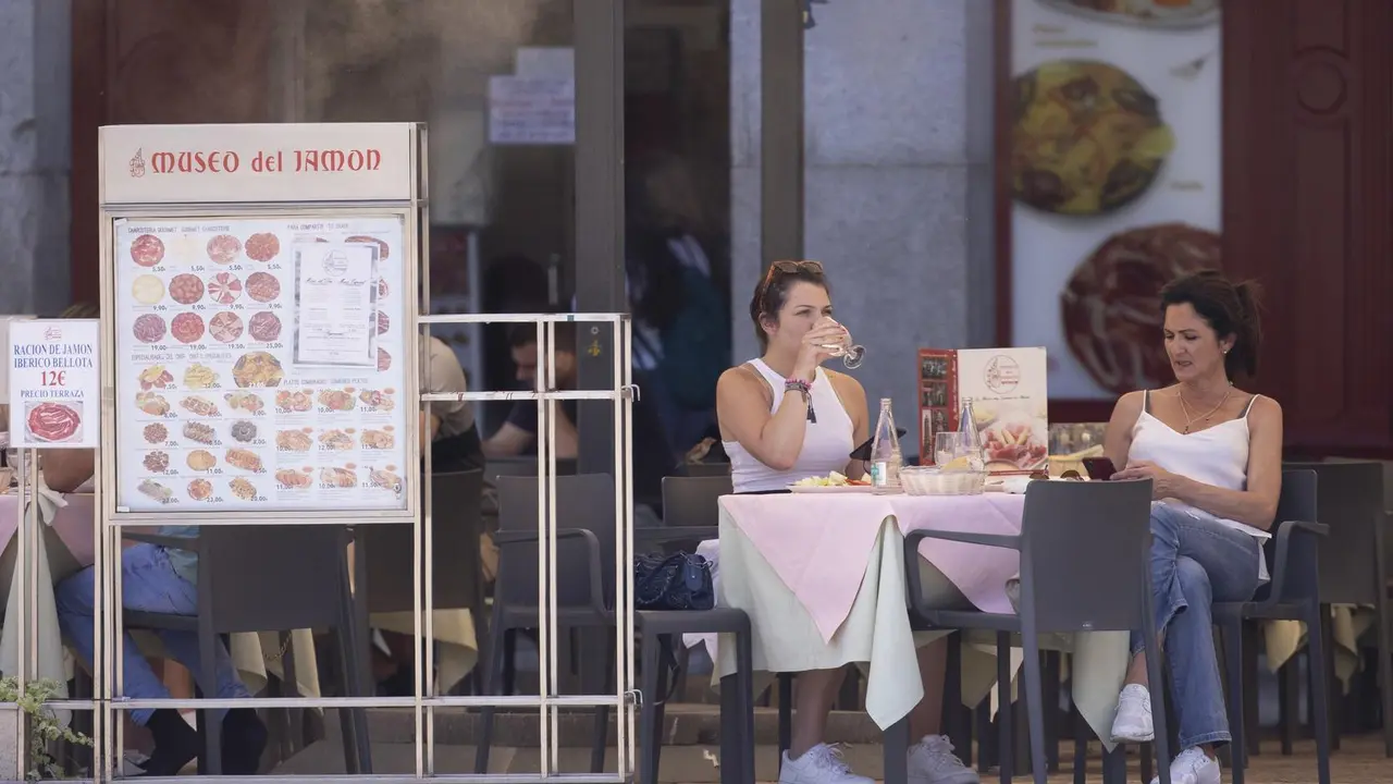Dos mujeres comen en una terraza del centro de la capital