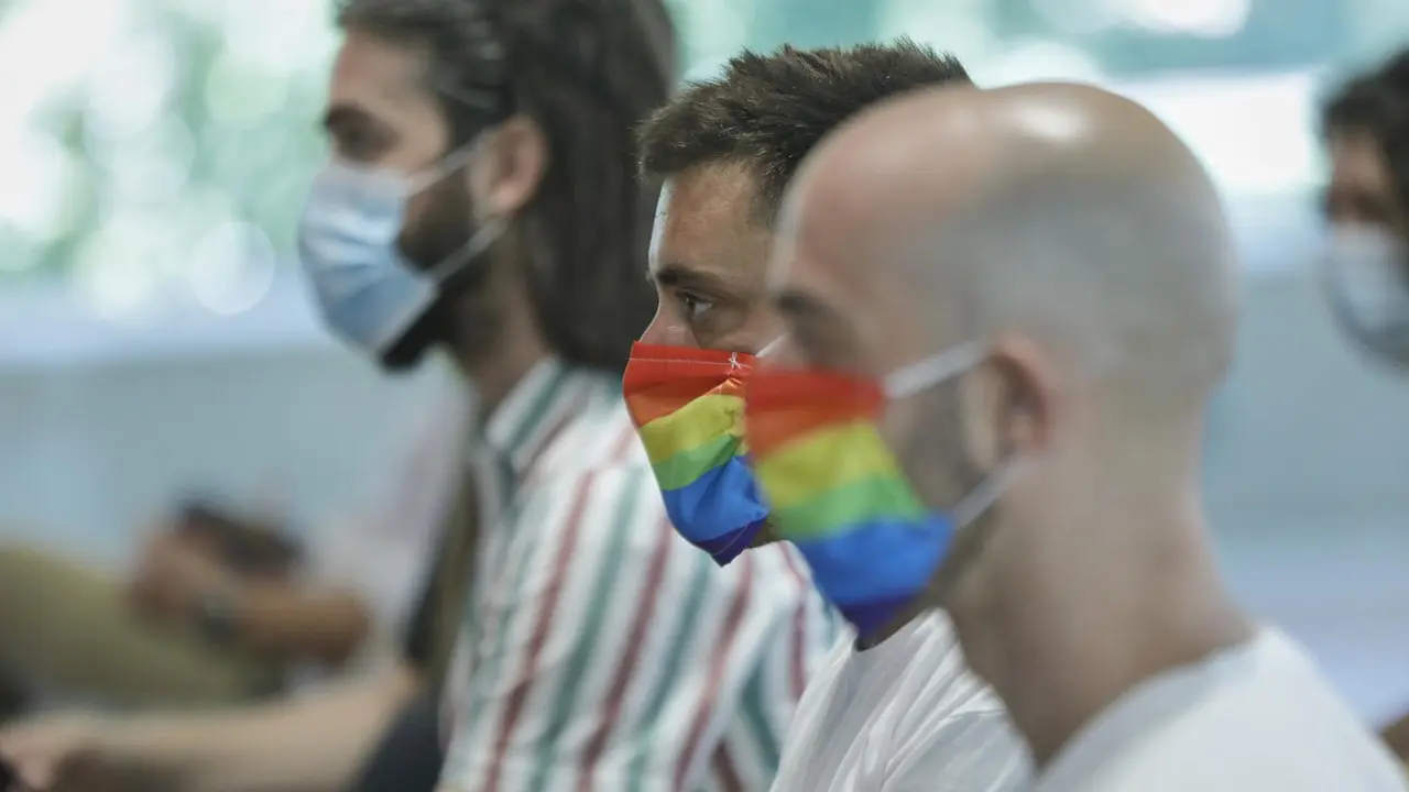 Archivo - Dos hombres se protegen con mascarillas con la bandera LGTBI