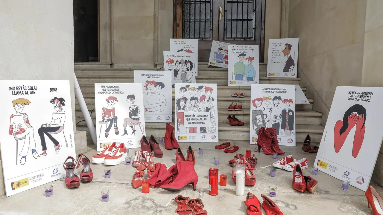 Varios pares de zapato de color rojo, velas y carteles contra la violencia contra las mujeres a las puertas de la Subdelegaci&oacute;n del Gobierno en Alicante, donde hoy se ha guardado un minuto de silencio en repulsa del asesinato machista de Wafaa Sebbah, 