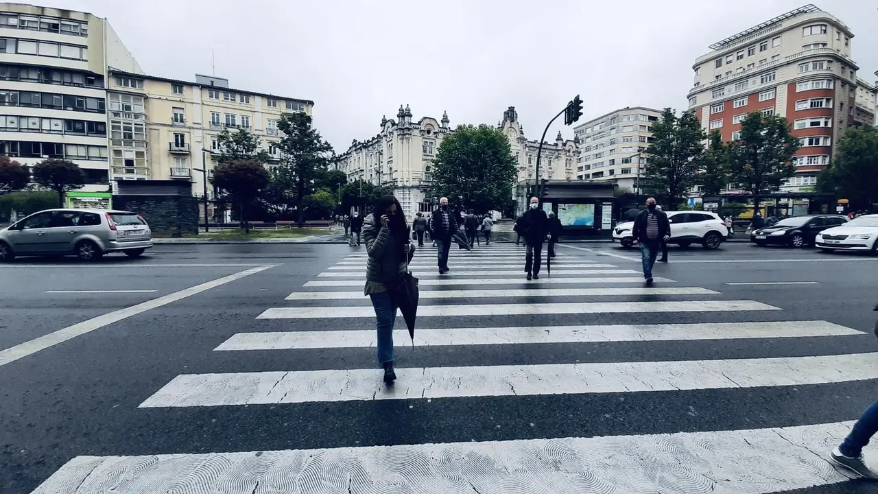 Varias personas cruzan una calle con su mascarilla puesta en el centro de Santander. / S. D&iacute;az