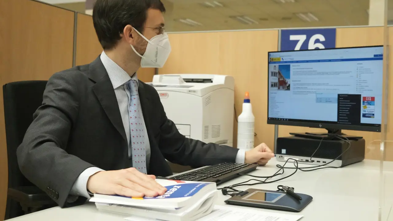 Un empleado trabaja en una oficina de la Agencia Tributaria, a 2 de junio de 2021, en Guzm&aacute;n el Bueno, Madrid, (Espa&ntilde;a). Las oficinas, que siguen afectadas por las medidas sanitarias de reducci&oacute;n de aforos y mantenimiento de distancias de seguridad en zon