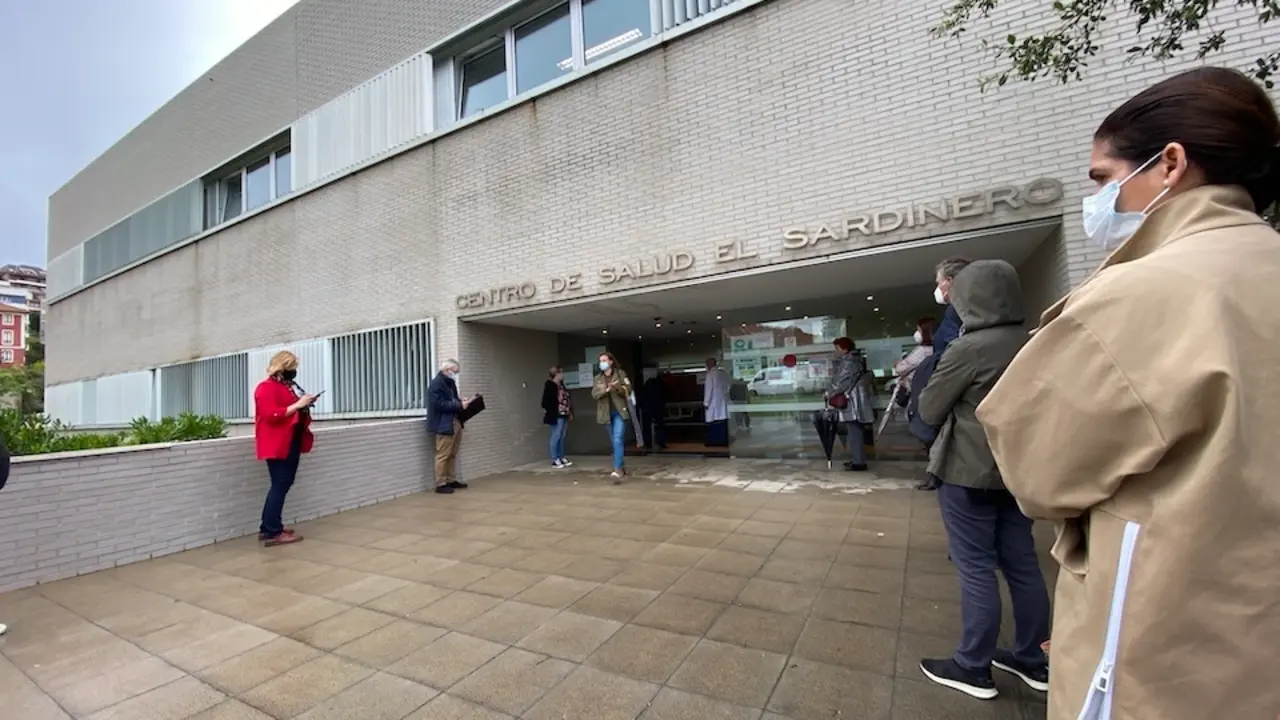 Varias personas esperan su turno para recibir la primera dosis de la vacuna en el centro de Salud del Sardinero. / HARDY