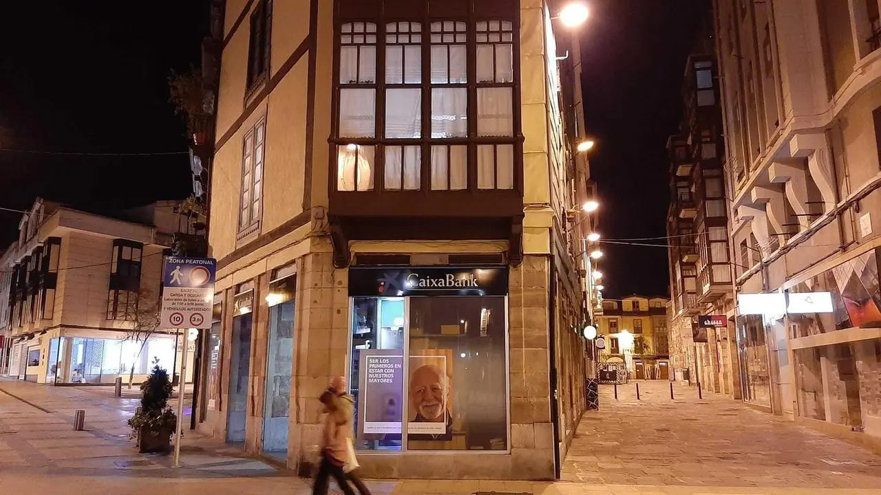 Dos personas camina en la noche de ayer por el centro de Torrelavega. / S. D&iacute;az