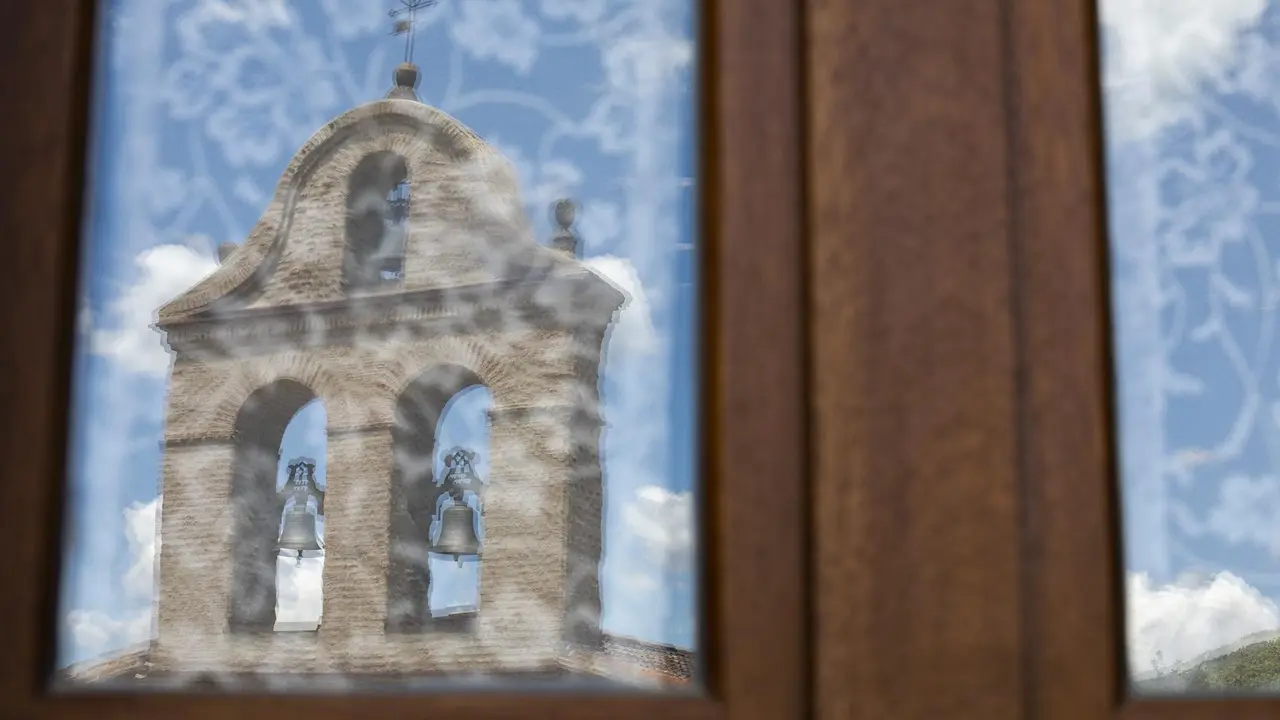 Reflejo de una iglesia en un cristal de una vivienda.