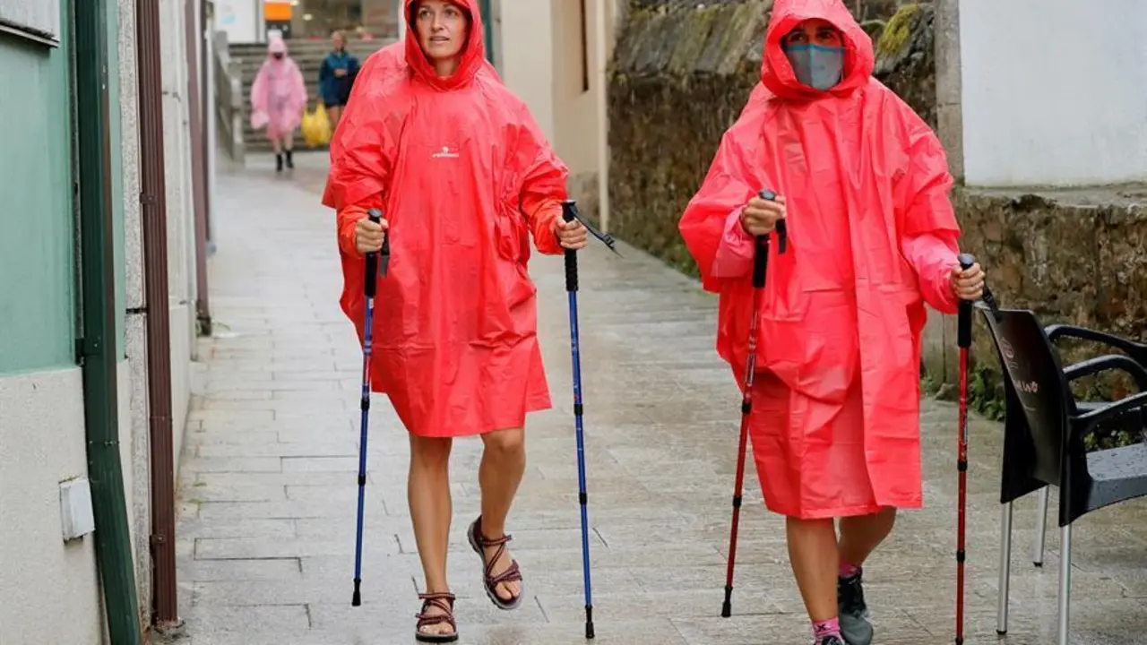 Pregrinos a su paso por Palas de Rei, en Lugo, este martes marcado por las lluvias. La Direcci&oacute;n Xeral de Emerxencias e Interior de la Vicepresidencia de la Xunta de Galicia ha activado una alerta naranja por tormentas y fuertes precipitaciones en las provincias de Lugo y Ourense. EFE/ Eliseo Trigo