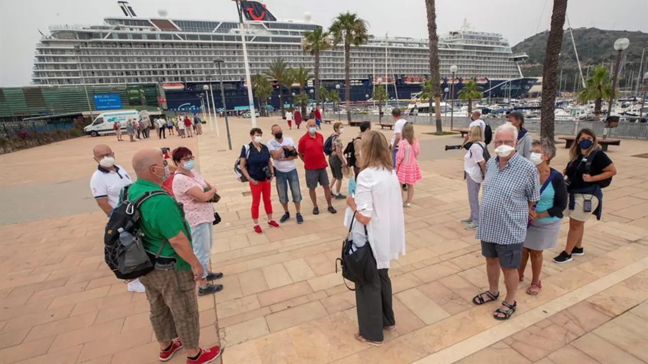 Un grupo de turistas alemanes del "Mein Schiff 2", el primer crucero que atraca en el Puerto de Cartagena tras la suspensi&oacute;n del turismo mar&iacute;timo desde marzo de 2020 a causa de la pandemia del coronavirus, atiende a las explicaciones de una gu&iacute;a tur&iacute;stica este s&aacute;bado. El "Mein Schiff 2" lleg&oacute; hoy a Cartagena con unos mil turistas alemanes a bordo procedentes de Palma de Mallorca. EFE/Marcial Guill&eacute;n