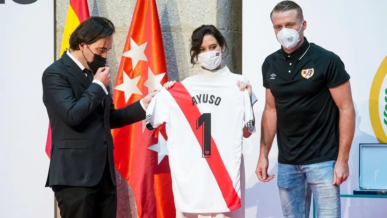 La presidenta de la Comunidad de Madrid, Isabel D&iacute;az Ayuso, posa con una camiseta de f&uacute;tbol con su nombre y con el presidente del Rayo Vallecano, Ra&uacute;l Mart&iacute;n Presa, y el capit&aacute;n Alberto Garc&iacute;a